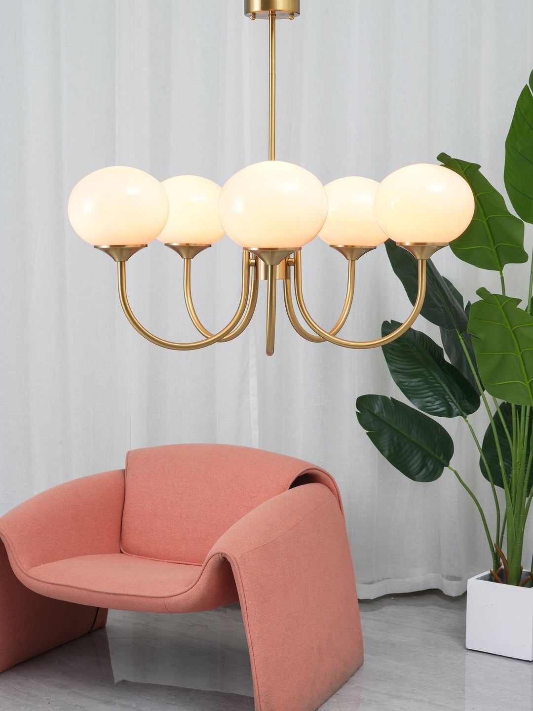Modern pink and gold chandelier with elegant glass shades, ideal ceiling light fixture for chic home decor and illumination.