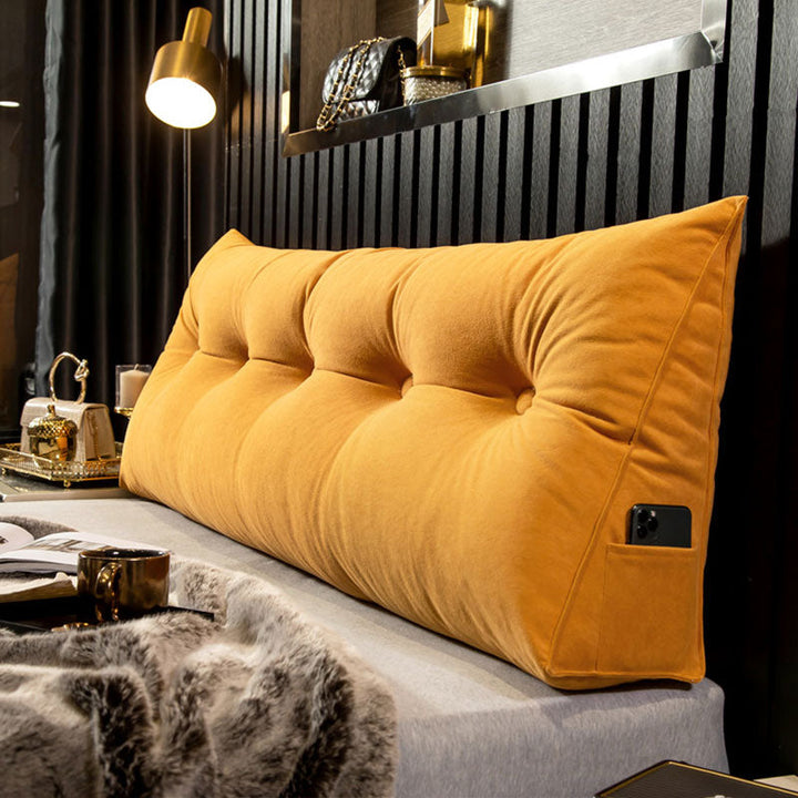 "Multi-coloured ergonomic wedge pillow for back support; shown in brown, yellow, and orange with a handy side pocket."