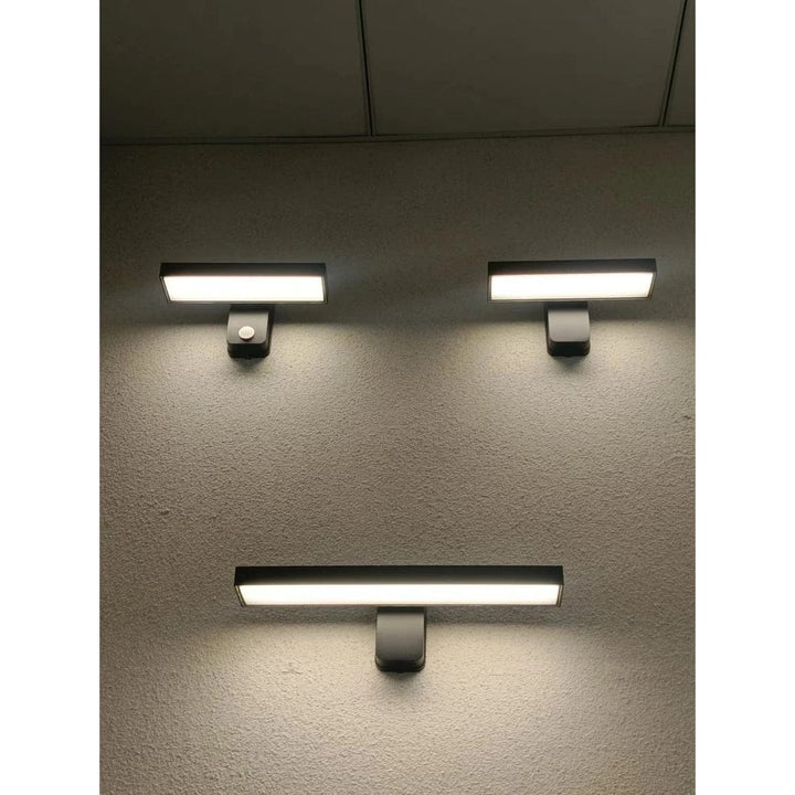 "Outdoor PIR motion sensor wall light, black aluminium, IP65 waterproof, rotatable design, warm white glow, modern style."