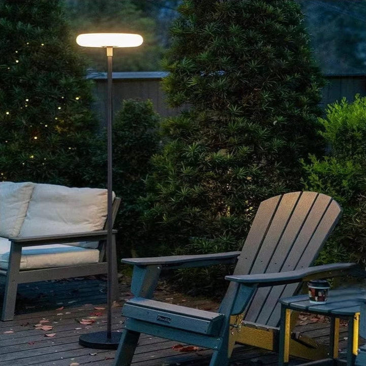 Outdoor solar floor lamp with metal and acrylic body, modern design, stands on patio illuminating with warm LED glow.