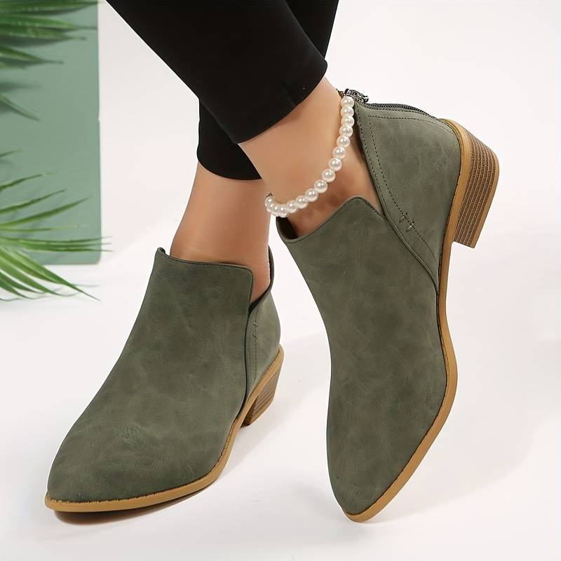 Side view of women's suede ankle boots with low block heel, pointed toe, and back zip, showcasing elegant and chic design.