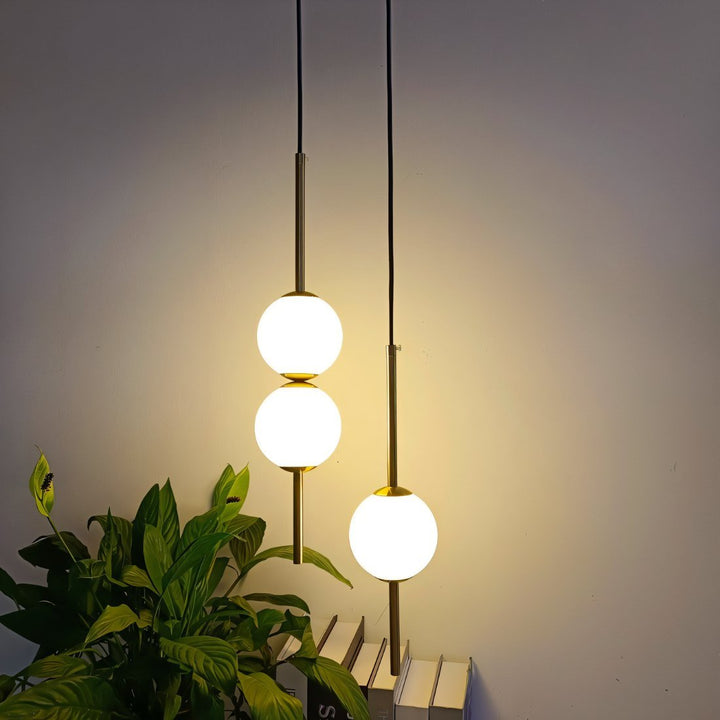 "Sleek glass ball Nordic pendant light with metal frame, LED bulb; available in black or brass, perfect for modern decor."