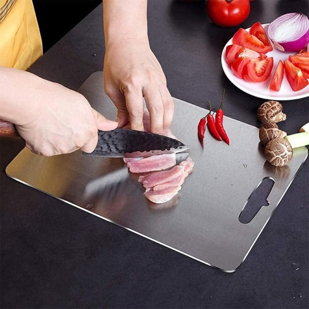 "Sleek stainless steel cutting board in use, showing durability and knife-friendly surface for kitchen prep tasks."