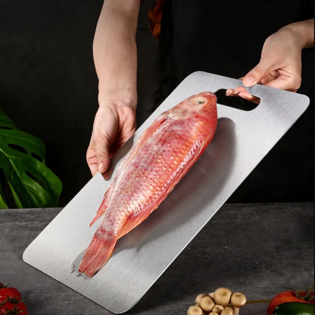 "Sleek stainless steel cutting board in use, showing durability and knife-friendly surface for kitchen prep tasks."