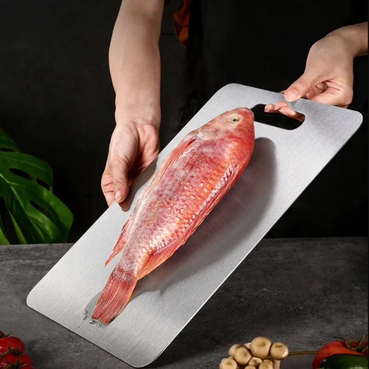 "Sleek stainless steel cutting board in use, showing durability and knife-friendly surface for kitchen prep tasks."