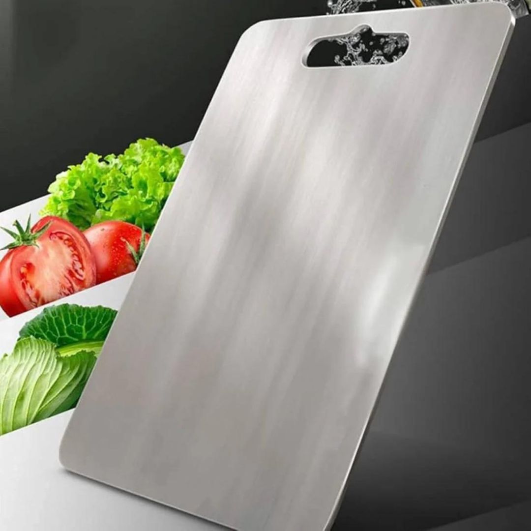 "Sleek stainless steel cutting board in use, showing durability and knife-friendly surface for kitchen prep tasks."