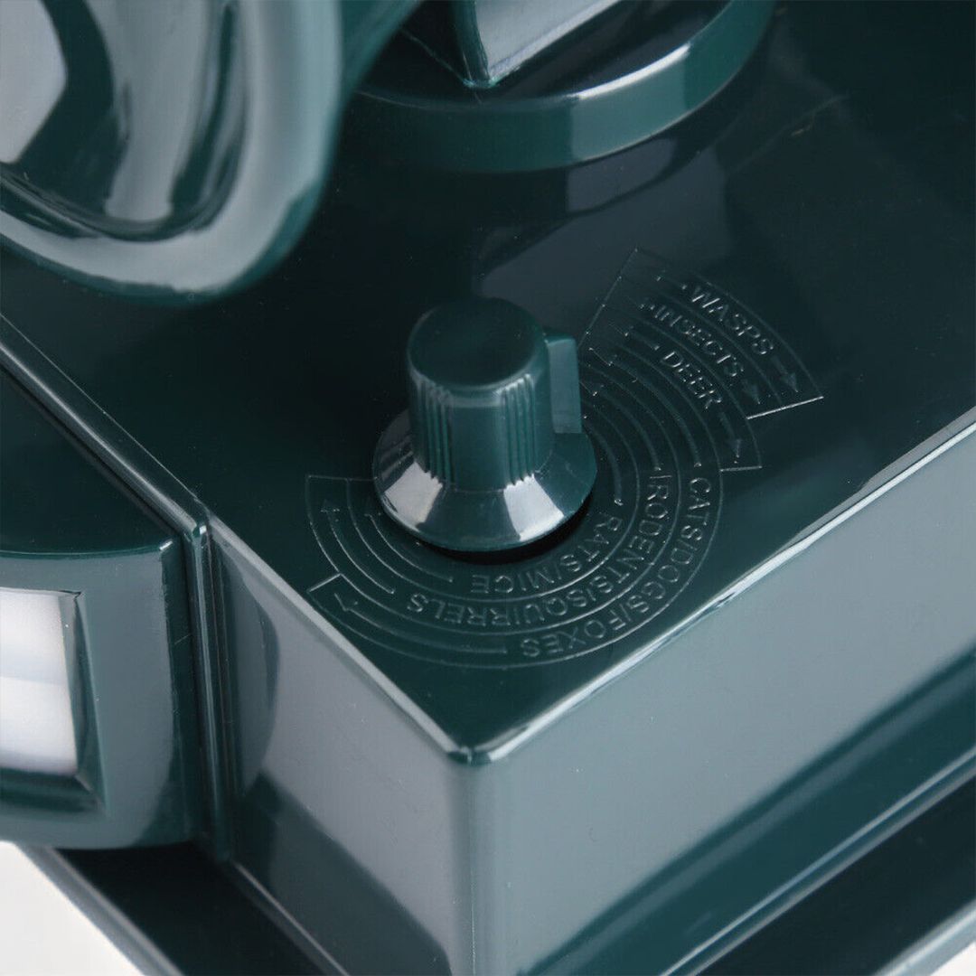 "Solar-powered motion sensor bird repeller, green and gray, for eco-friendly outdoor pest control in gardens and patios."