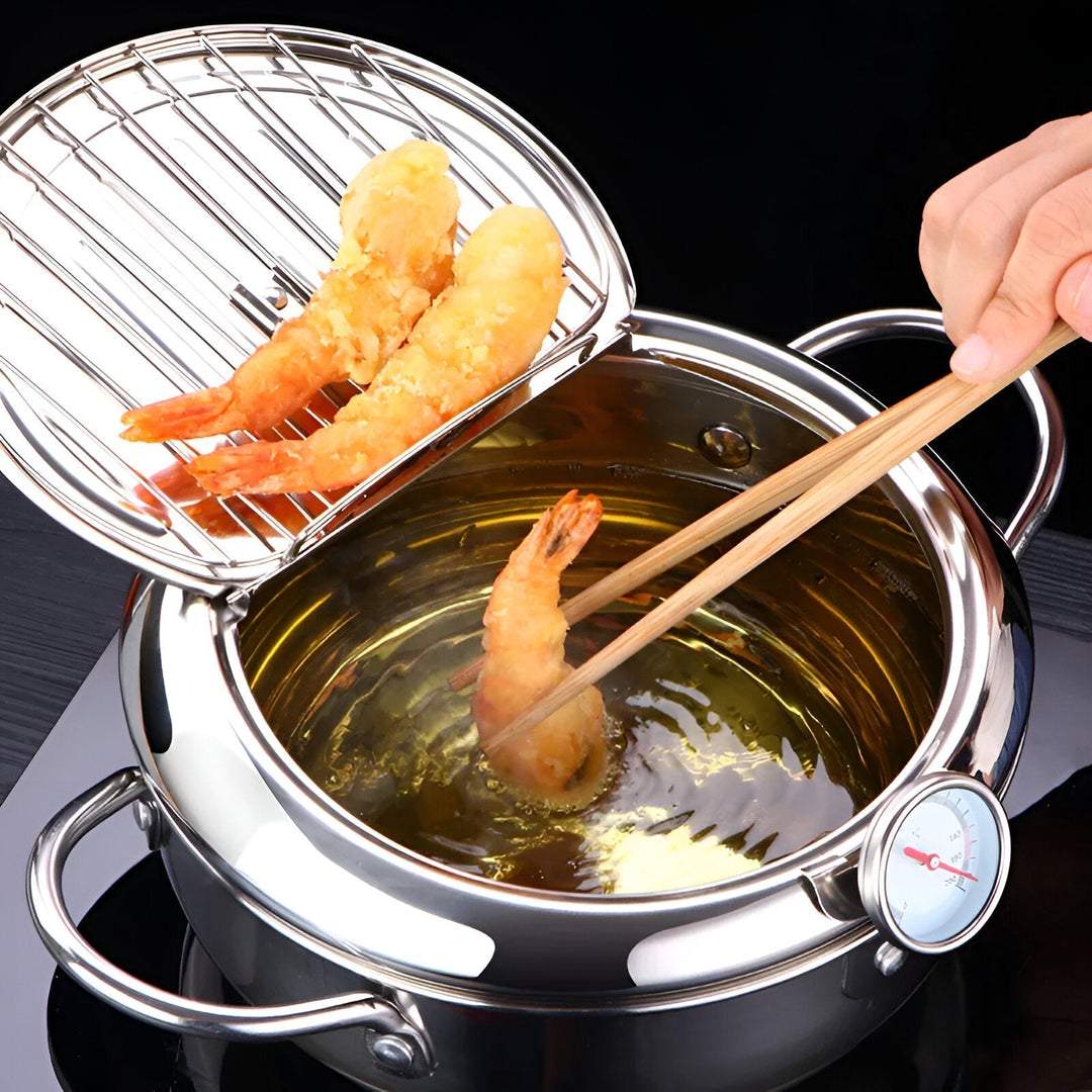 "Stainless steel deep fryer pot with thermometer, silver, heat-resistant handles, and oil drainer rack for safe frying."