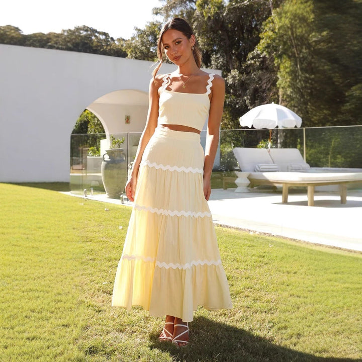 Strapless crop top and tiered maxi skirt set, lightweight with wavy trim, perfect for summer events. Women's fashion ensemble