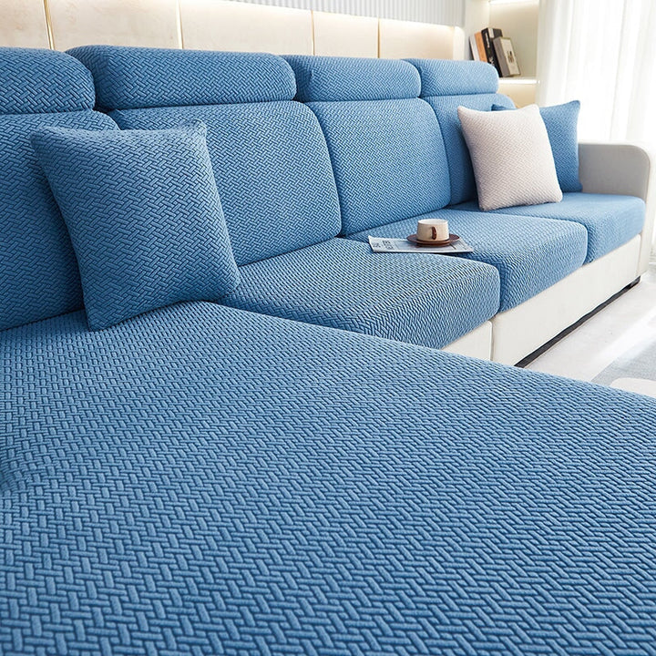Stretchable sectional sofa cover in vibrant tangerine, snug fit, durable fabric, ideal for home decor and furniture protectio