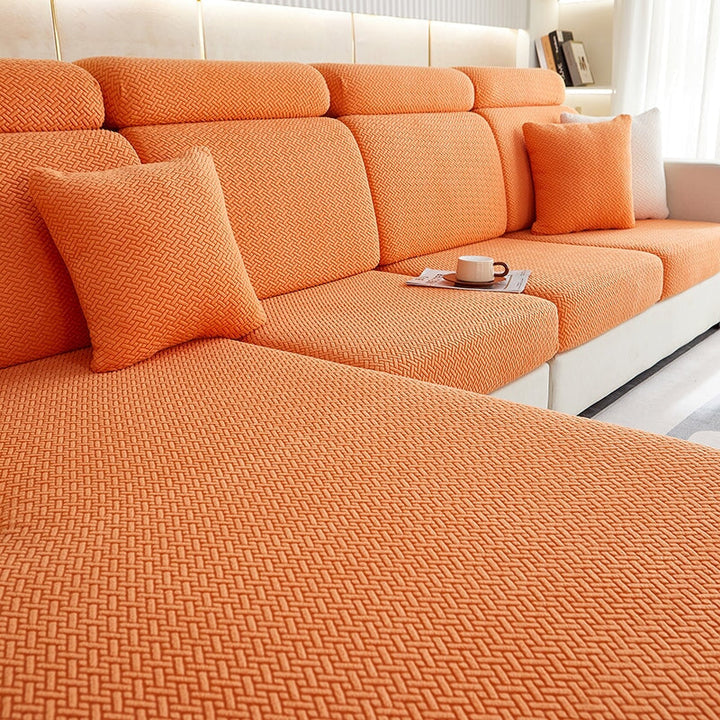 Stretchable sectional sofa cover in vibrant tangerine, snug fit, durable fabric, ideal for home decor and furniture protectio