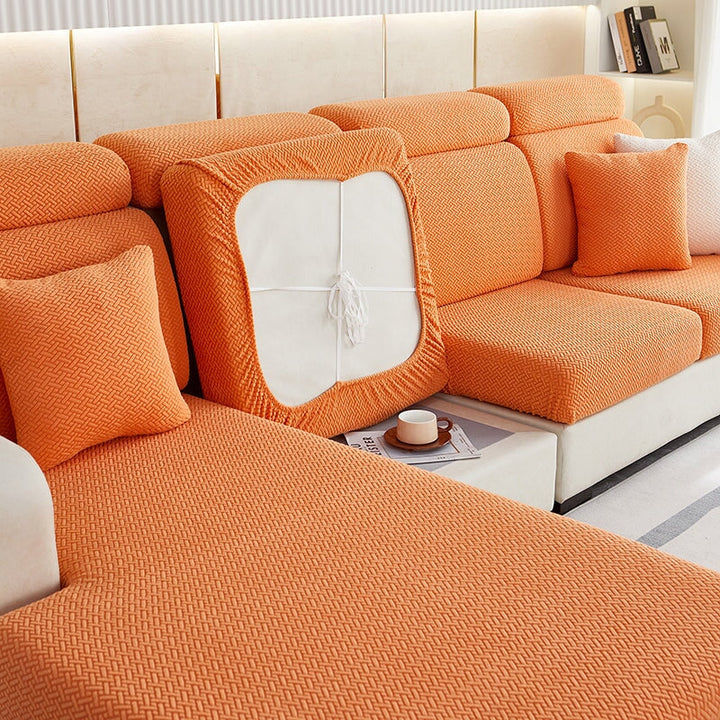 Stretchable sectional sofa cover in vibrant tangerine, snug fit, durable fabric, ideal for home decor and furniture protectio