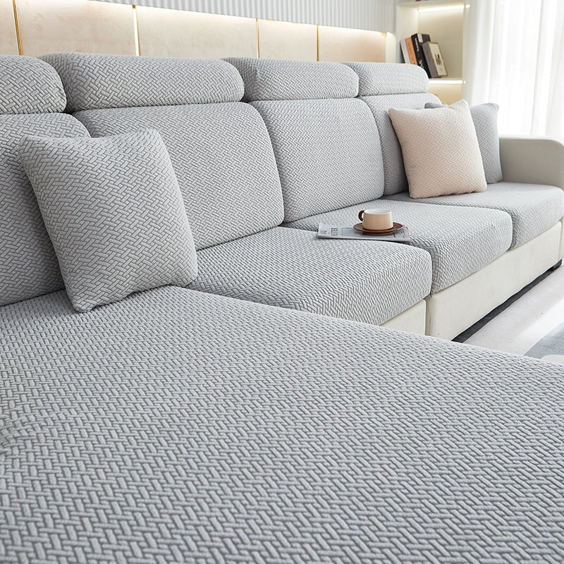 Stretchable sectional sofa cover in vibrant tangerine, snug fit, durable fabric, ideal for home decor and furniture protectio