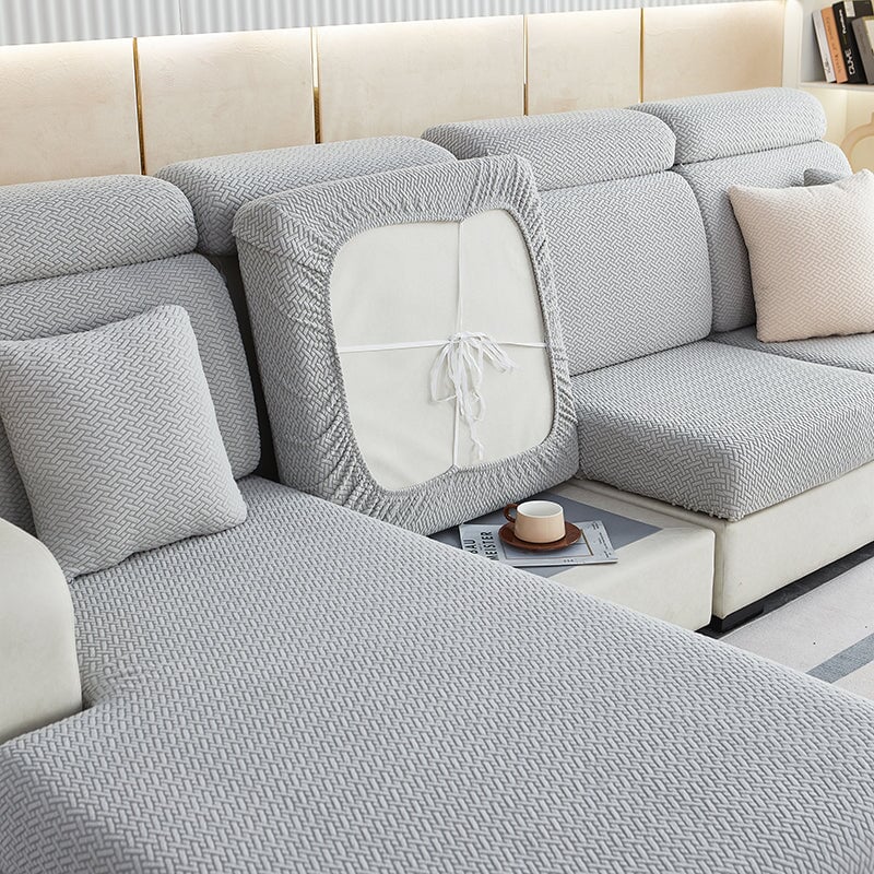 Stretchable sectional sofa cover in vibrant tangerine, snug fit, durable fabric, ideal for home decor and furniture protectio