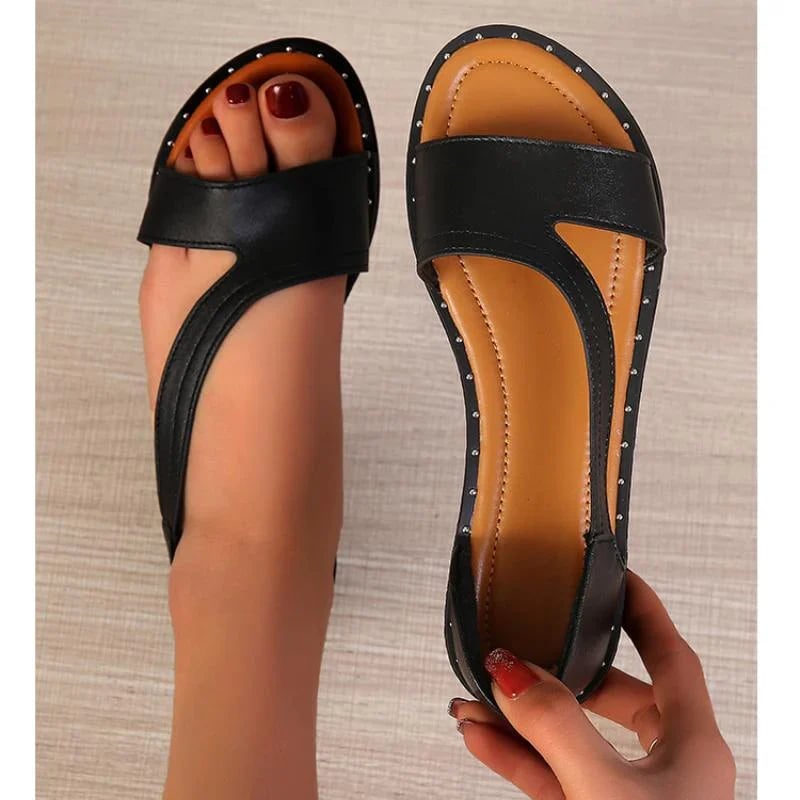 "Stylish open-toe women's sandals in black and white, featuring modern cutout strap and cushioned soles for comfort."