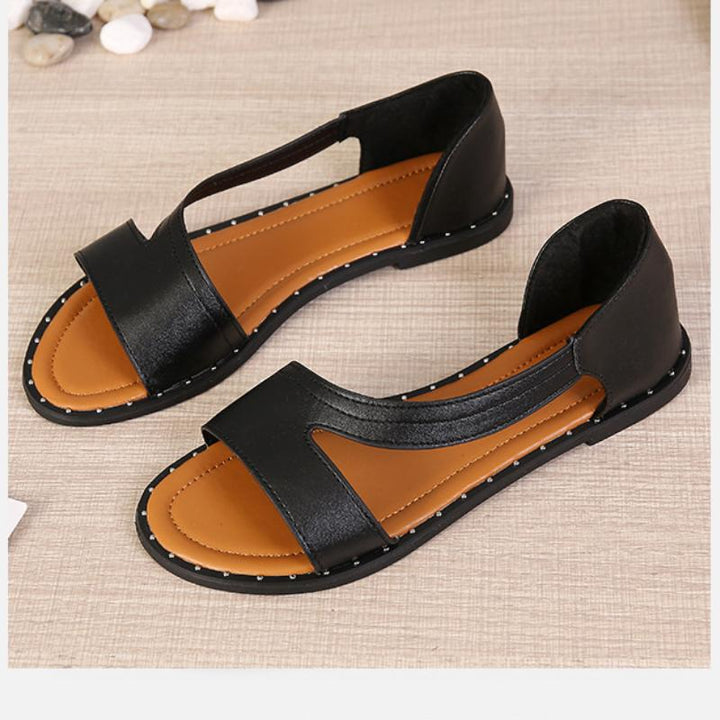 "Stylish open-toe women's sandals in black and white, featuring modern cutout strap and cushioned soles for comfort."