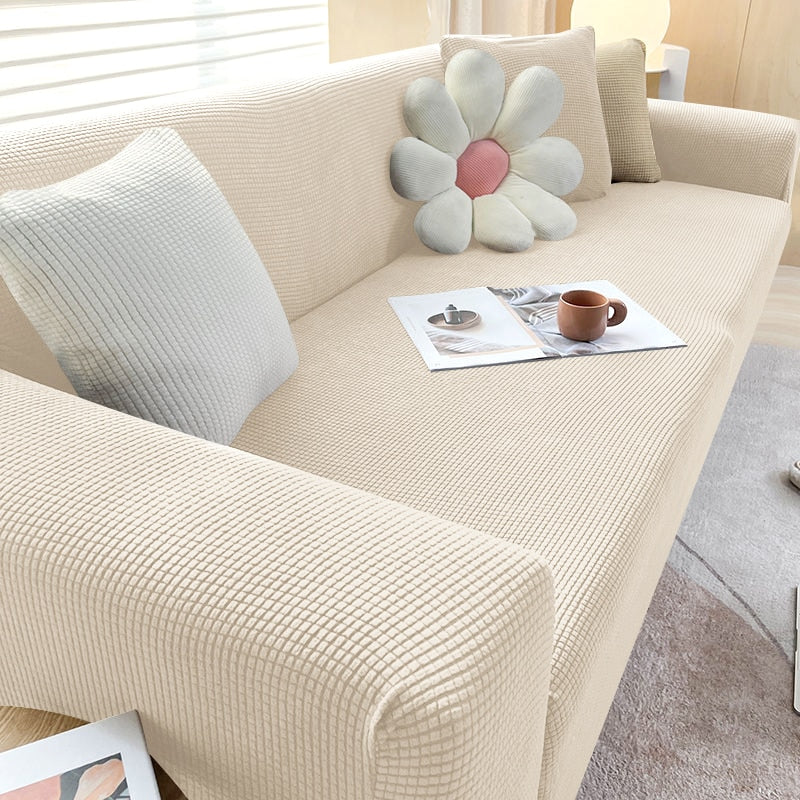 "Textured stretch sofa cover in beige, snug fit for sofas, non-slip, adds elegance, protects against spills and wear."