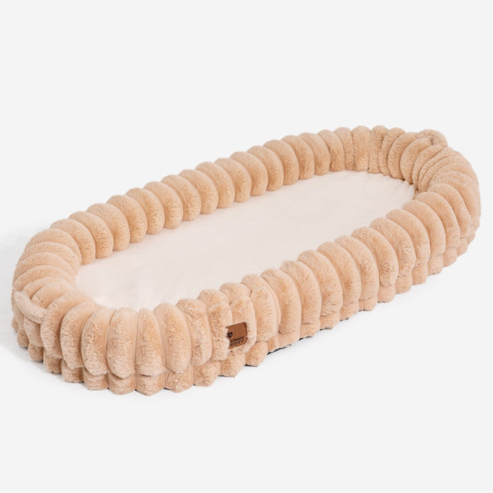 Ultra-soft large plush donut pet bed, creamy faux fur with bolsters for head support, fits humans and dogs, cozy design.