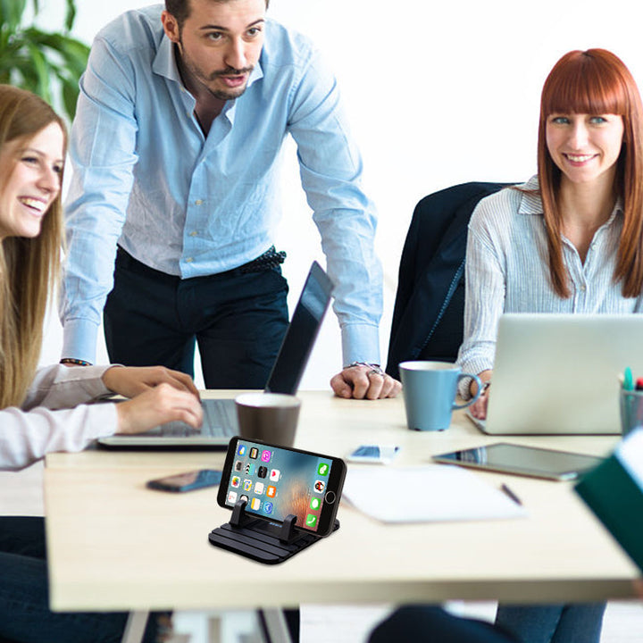 Universal non-slip phone holder for cars with silicone grip, securely holding a smartphone on a dashboard for safe driving.