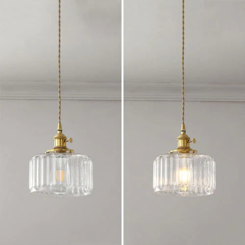 Vintage cylindrical glass pendant lamp casting warm glow; elegant centerpiece for home decor. Perfect for living and dining a