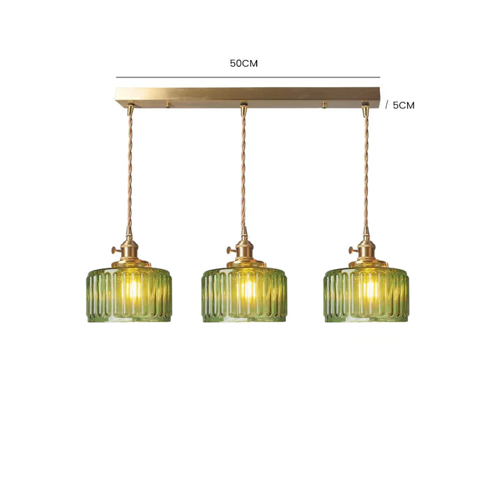 Vintage cylindrical glass pendant lamp casting warm glow; elegant centerpiece for home decor. Perfect for living and dining a