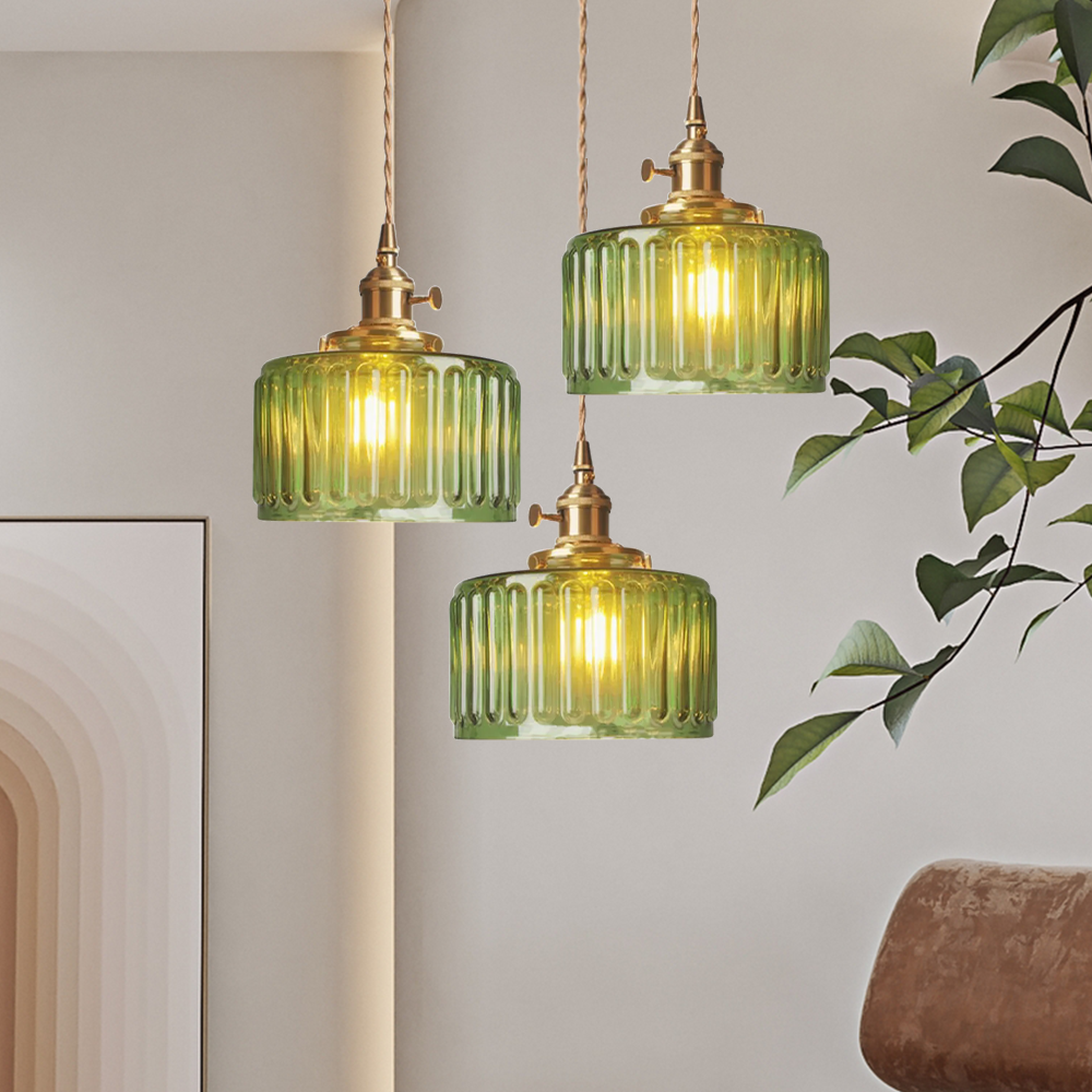 Vintage cylindrical glass pendant lamp casting warm glow; elegant centerpiece for home decor. Perfect for living and dining a