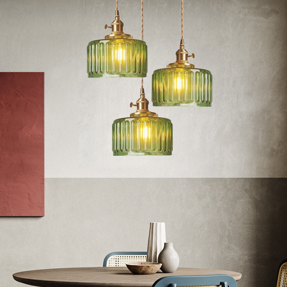 Vintage cylindrical glass pendant lamp casting warm glow; elegant centerpiece for home decor. Perfect for living and dining a