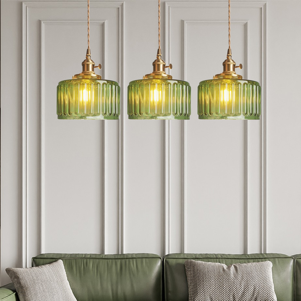 Vintage cylindrical glass pendant lamp casting warm glow; elegant centerpiece for home decor. Perfect for living and dining a