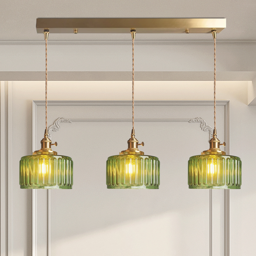 Vintage cylindrical glass pendant lamp casting warm glow; elegant centerpiece for home decor. Perfect for living and dining a