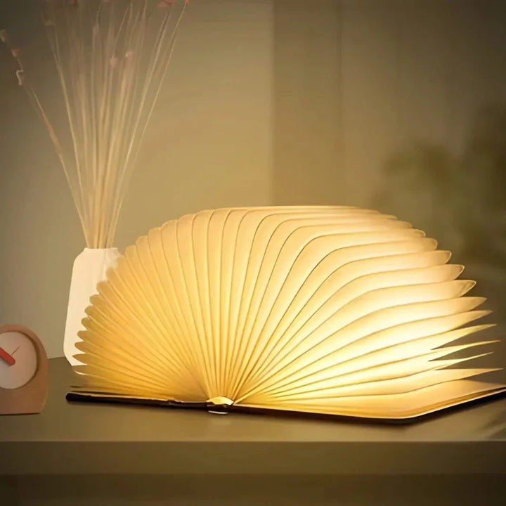 "Whimsical LED book lamp with warm glow, resembling an open book, perfect for cozy decor in bedrooms or study areas."