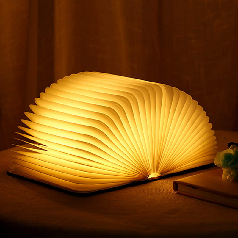"Whimsical LED book lamp with warm glow, resembling an open book, perfect for cozy decor in bedrooms or study areas."