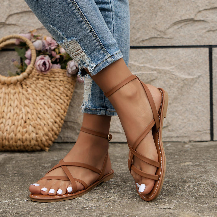 Women's casual Roman sandals with zipper back, strappy design, secure ankle strap, criss-cross detailing, flat sole.