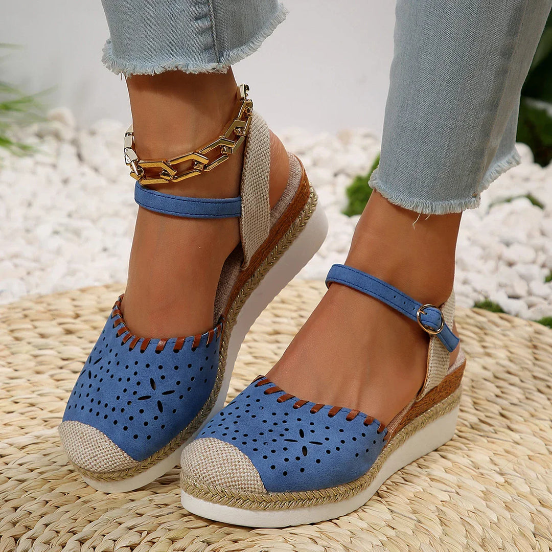 Women's closed-toe espadrille wedge sandals with ankle strap, featuring a stylish perforated toe and secure buckle fit.