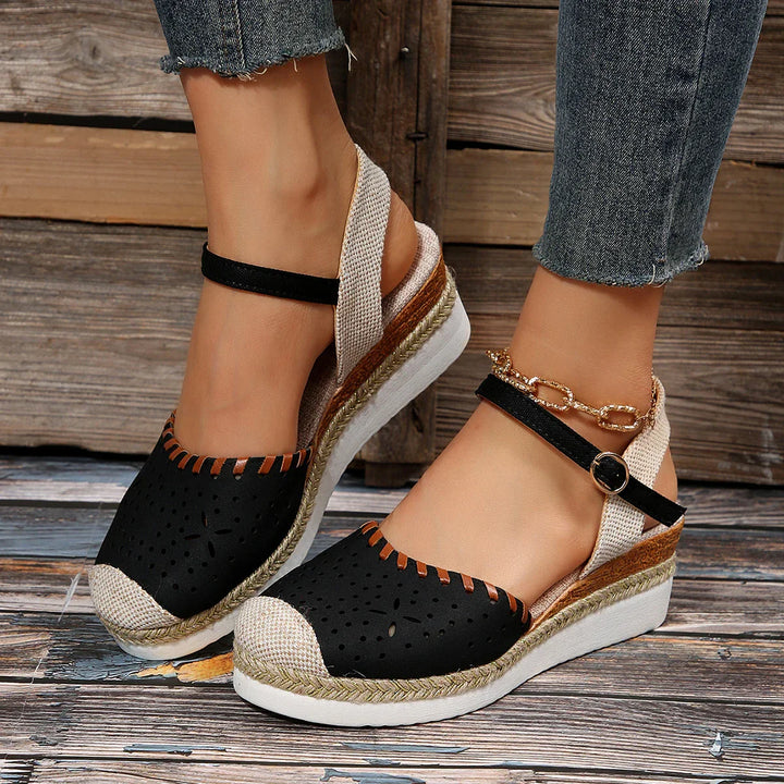 Women's closed-toe espadrille wedge sandals with ankle strap, featuring a stylish perforated toe and secure buckle fit.