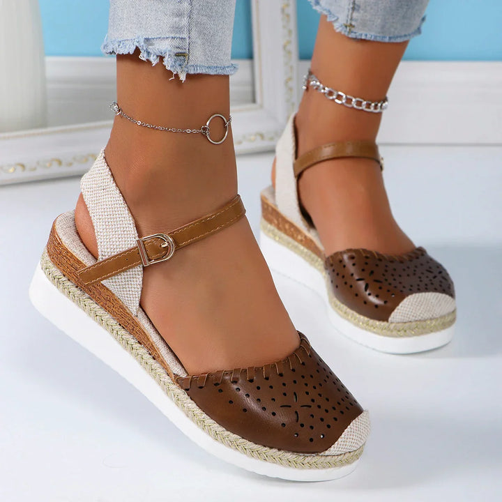 Women's closed-toe espadrille wedge sandals with ankle strap, featuring a stylish perforated toe and secure buckle fit.