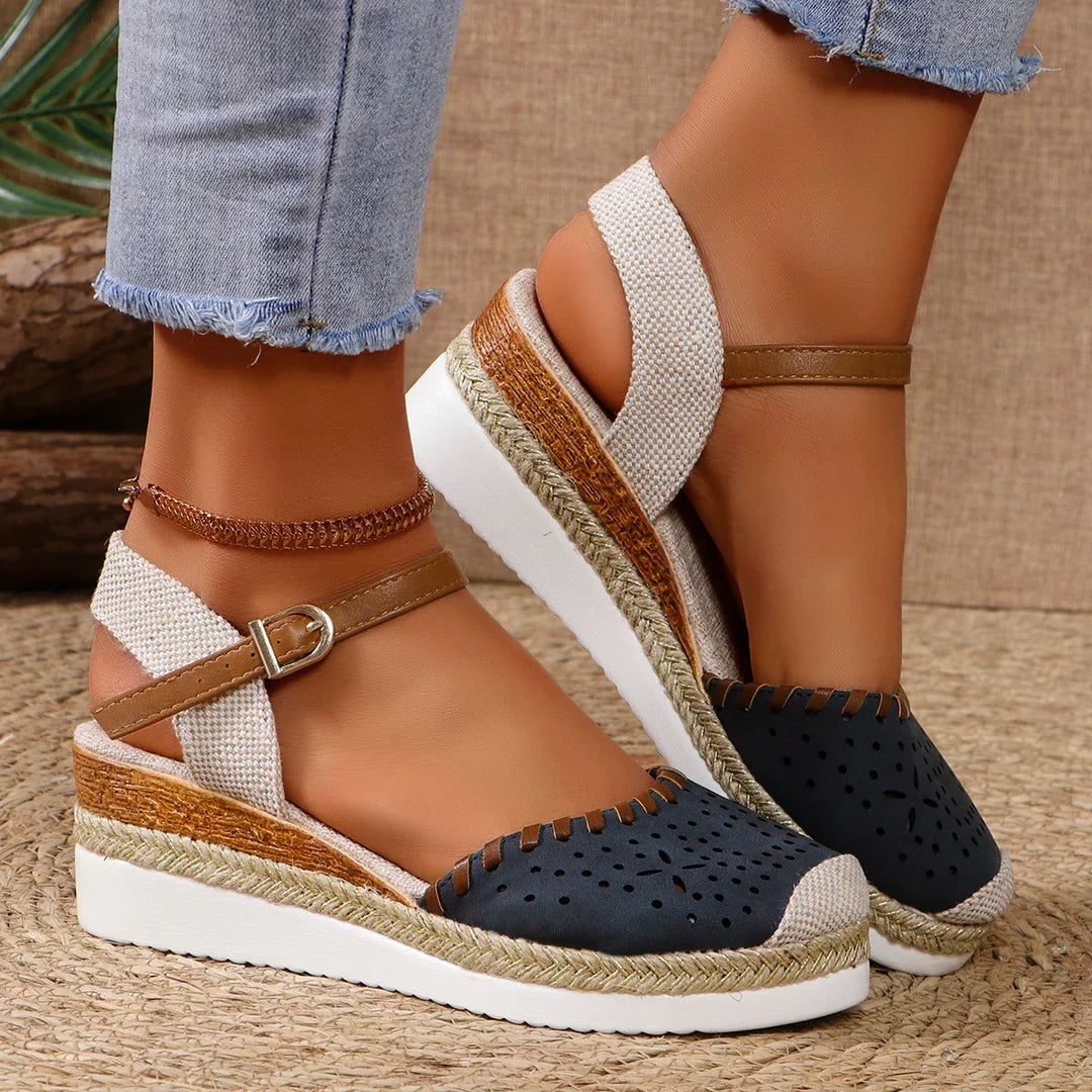 Women's closed-toe espadrille wedge sandals with ankle strap, featuring a stylish perforated toe and secure buckle fit.