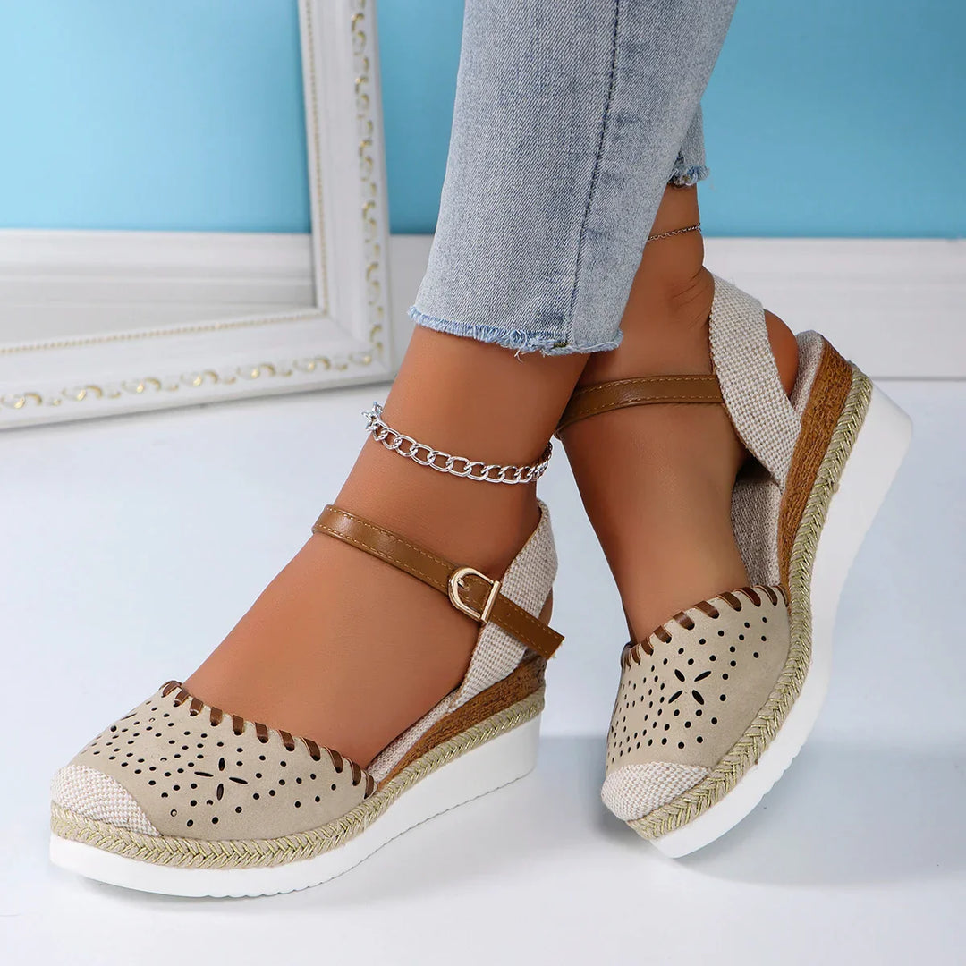 Women's closed-toe espadrille wedge sandals with ankle strap, featuring a stylish perforated toe and secure buckle fit.