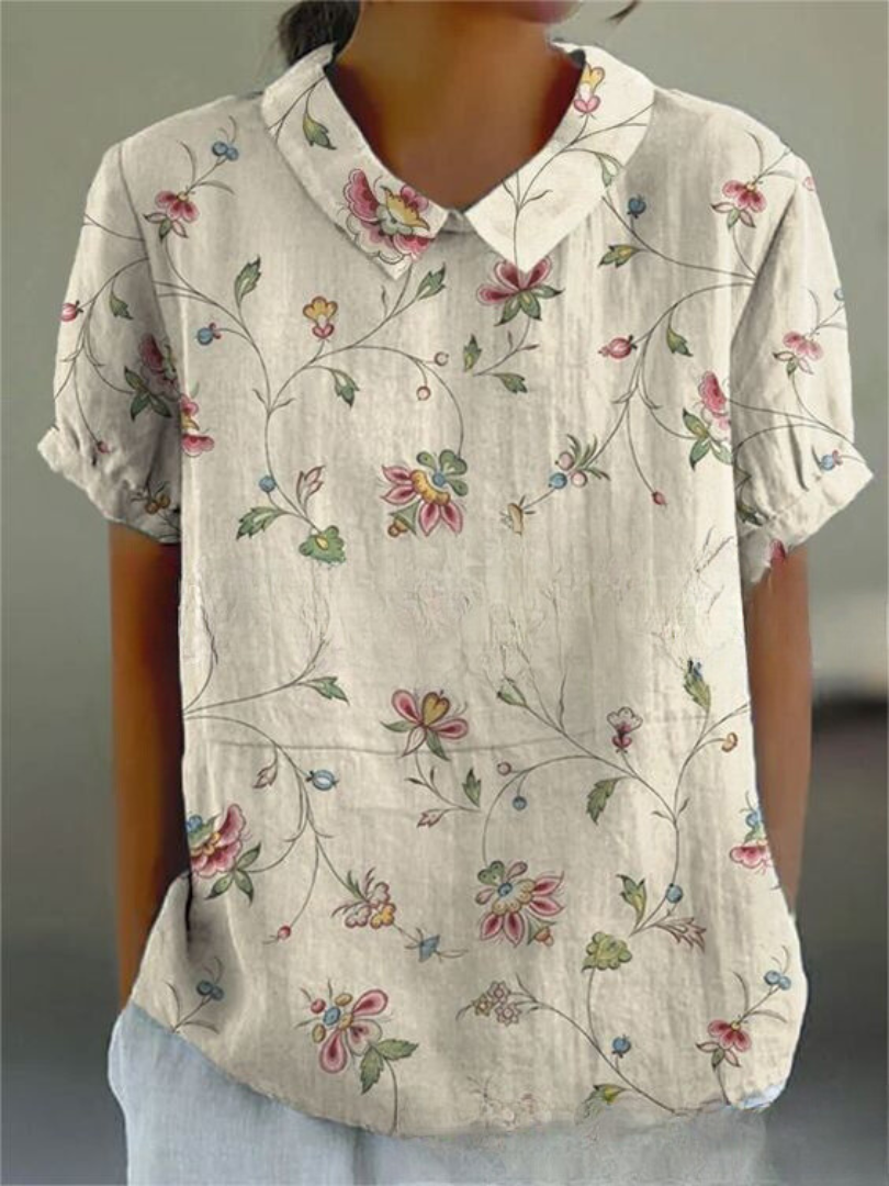 Women's elegant floral blouse with short sleeves and Peter Pan collar, featuring a vibrant floral pattern for stylish summer 