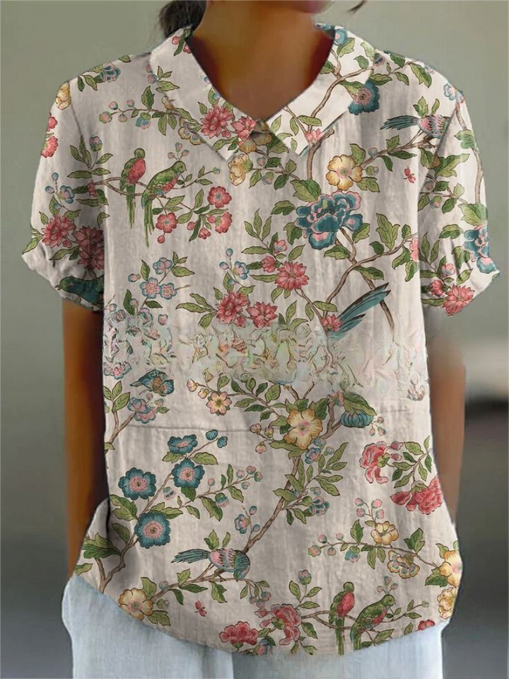 Women's elegant floral blouse with short sleeves and Peter Pan collar, featuring a vibrant floral pattern for stylish summer 