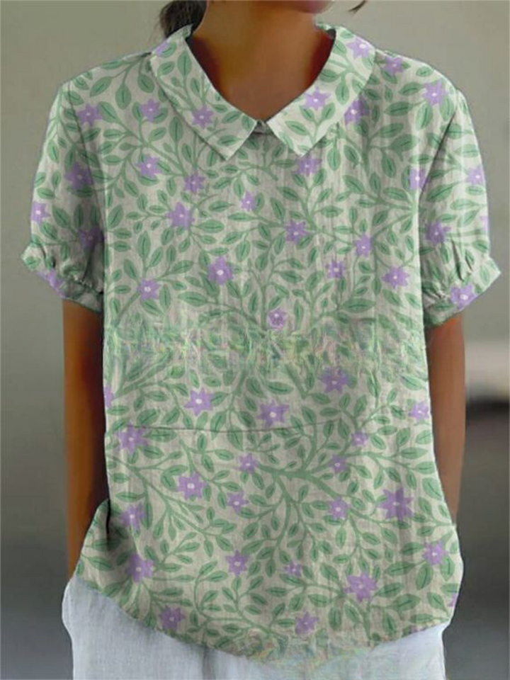 Women's elegant floral blouse with short sleeves and Peter Pan collar, featuring a vibrant floral pattern for stylish summer 