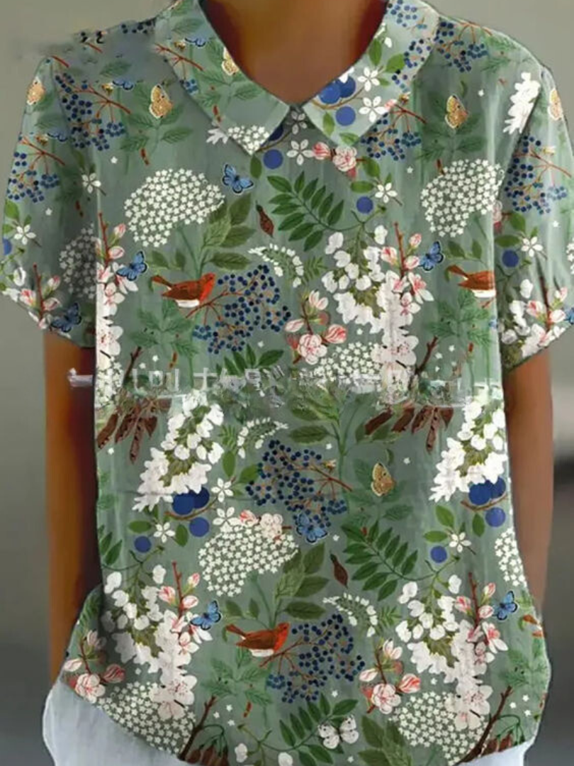 Women's elegant floral blouse with short sleeves and Peter Pan collar, featuring a vibrant floral pattern for stylish summer 
