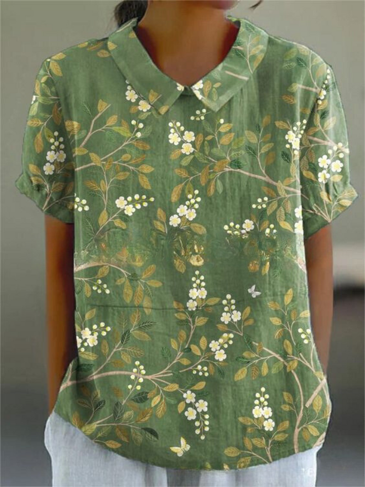 Women's elegant floral blouse with short sleeves and Peter Pan collar, featuring a vibrant floral pattern for stylish summer 