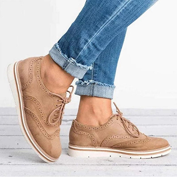 Women's lace-up brogue trainers with flat sole, featuring classic design and secure closure for elegant, comfortable wear.