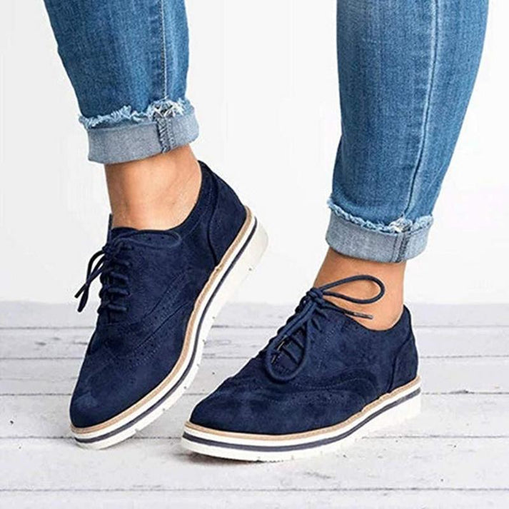 Women's lace-up brogue trainers with flat sole, featuring classic design and secure closure for elegant, comfortable wear.