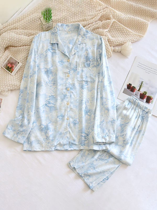 Women's luxurious cotton long-sleeve pyjama set, soft breathable fabric, elegant two-piece design in light pastel colors.