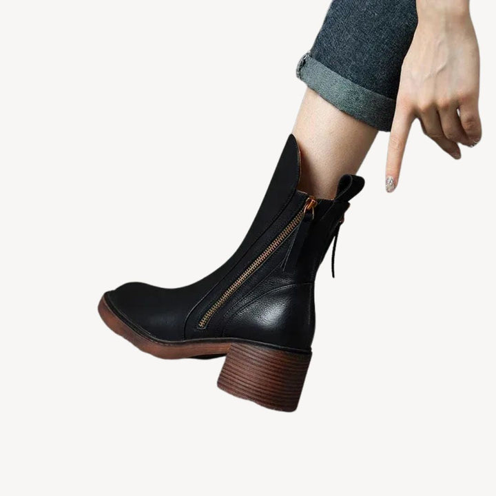 "Women's orthopedic black leather ankle boots with side zipper and moderate heel for comfort and style."