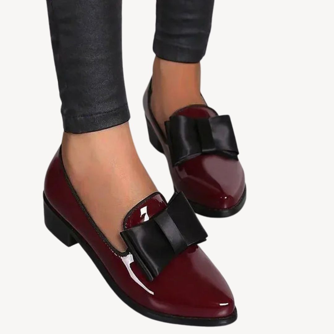 Women's patent leather loafers with bow, in burgundy and black, sleek high-shine finish, elegant and comfortable footwear.