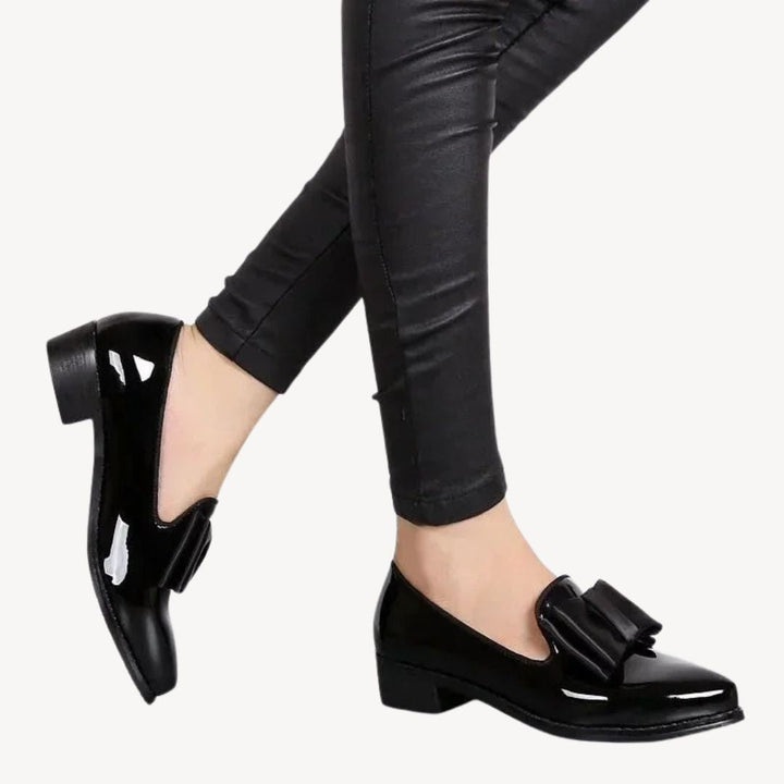 Women's patent leather loafers with bow, in burgundy and black, sleek high-shine finish, elegant and comfortable footwear.