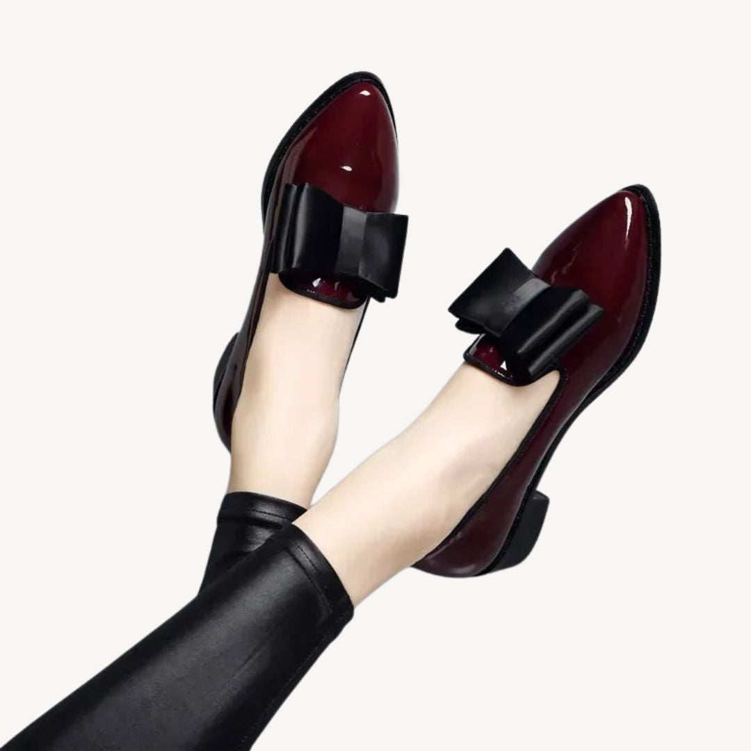 Women's patent leather loafers with bow, in burgundy and black, sleek high-shine finish, elegant and comfortable footwear.