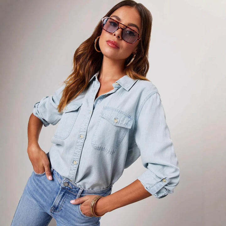 "Women's relaxed fit denim shirt with button-down front, chest pockets, in light blue, perfect for casual elegance."